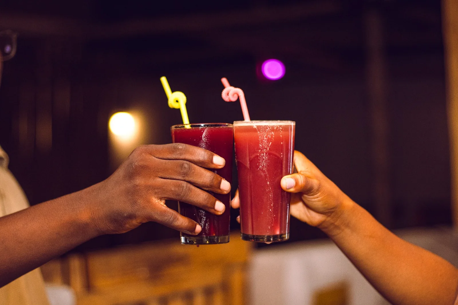 Deux verres de jus maison trinqués au-dessus d'une table à Ô Coin BBQ